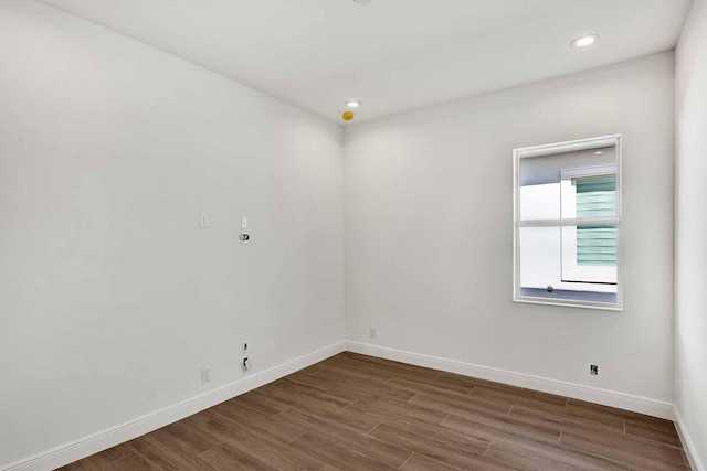 unfurnished room featuring baseboards, dark wood-style floors, and recessed lighting