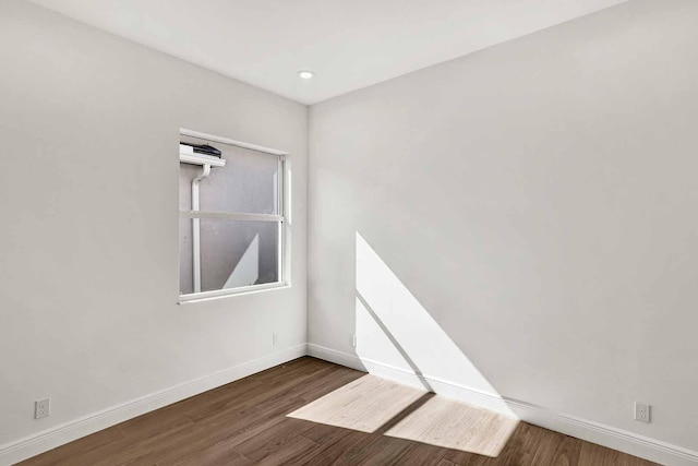 empty room featuring recessed lighting, baseboards, and wood finished floors