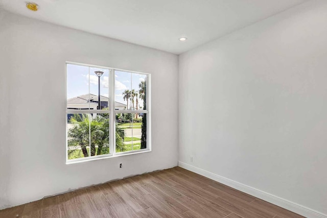 unfurnished room featuring recessed lighting, a healthy amount of sunlight, and wood finished floors