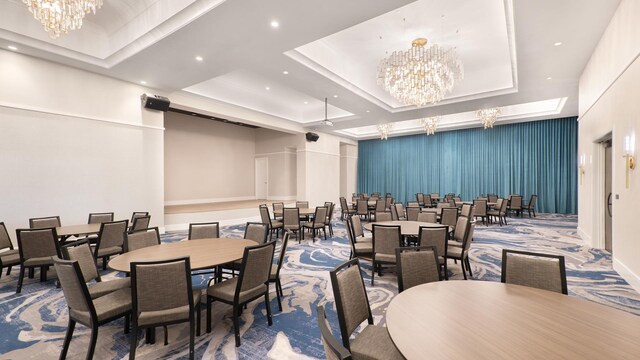 dining room with an inviting chandelier, a raised ceiling, and recessed lighting