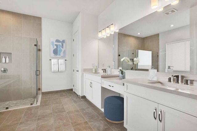 bathroom with a stall shower, baseboards, visible vents, and vanity