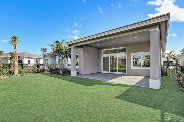 back of house with stucco siding, fence, a patio, a residential view, and a lawn