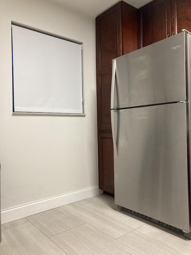 kitchen featuring dark brown cabinetry and stainless steel fridge