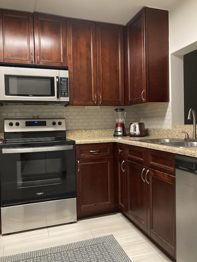 kitchen featuring tasteful backsplash, sink, and appliances with stainless steel finishes