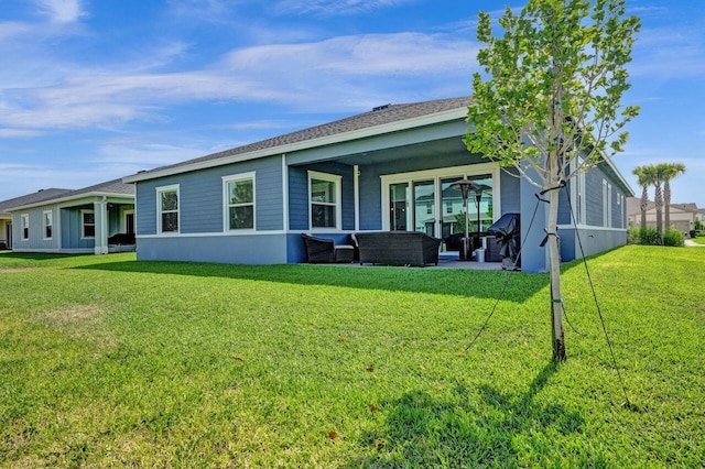 rear view of property featuring a lawn and a patio area