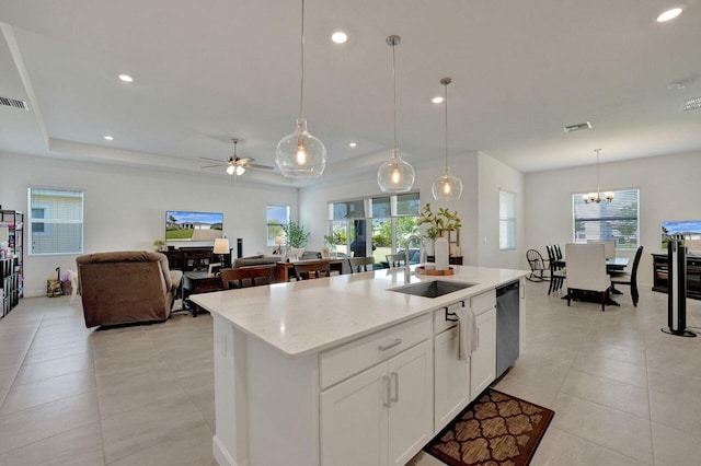 kitchen featuring an island with sink, white cabinets, pendant lighting, sink, and dishwasher