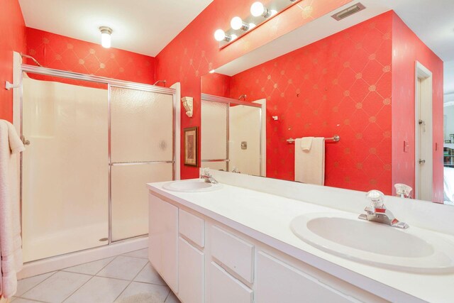 bathroom featuring tile floors, walk in shower, and double vanity