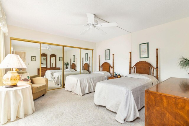 carpeted bedroom featuring a closet and ceiling fan