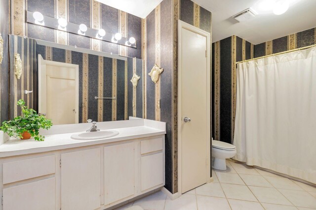 bathroom with tile flooring, toilet, and large vanity