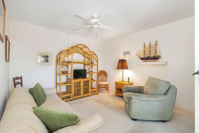 carpeted living room featuring a textured ceiling and ceiling fan