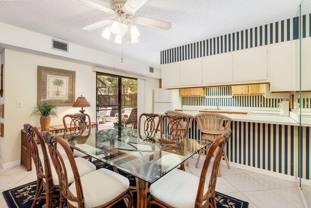 tiled dining room featuring sink, a textured ceiling, and ceiling fan