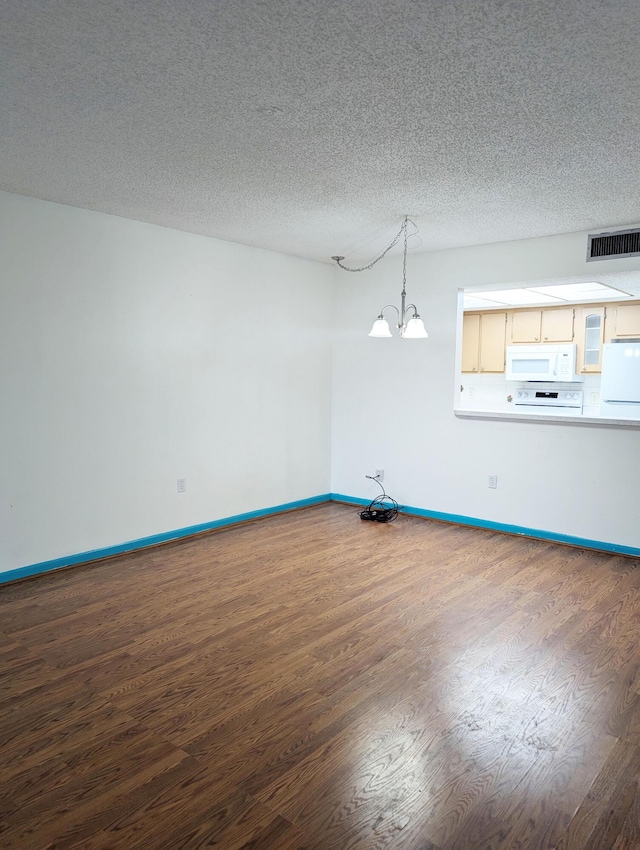 unfurnished dining area with an inviting chandelier, hardwood / wood-style flooring, and a textured ceiling