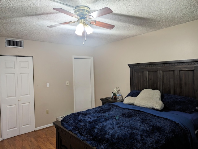 bedroom with ceiling fan, a textured ceiling, and wood-type flooring