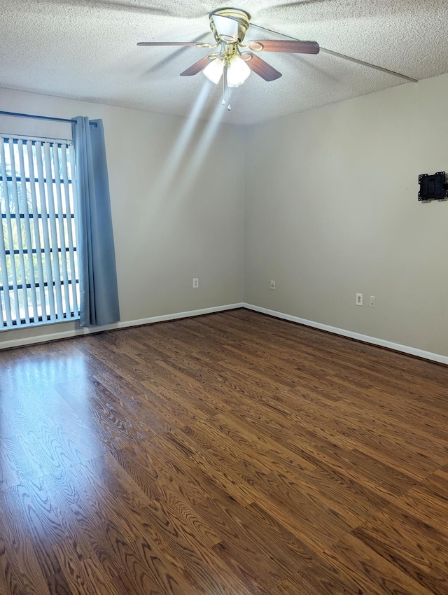 spare room featuring ceiling fan, dark hardwood / wood-style flooring, and a textured ceiling