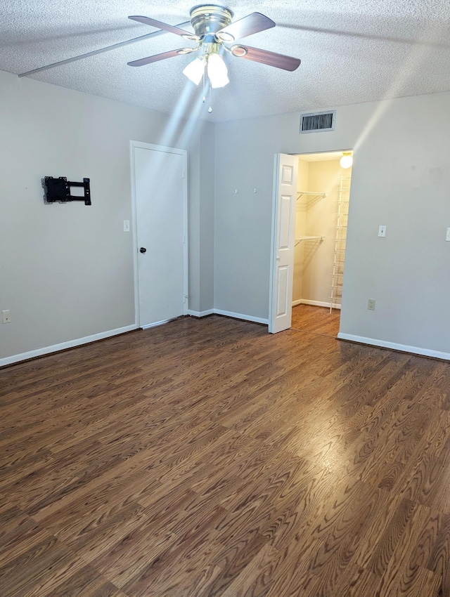 interior space with ceiling fan, dark wood-type flooring, and a textured ceiling