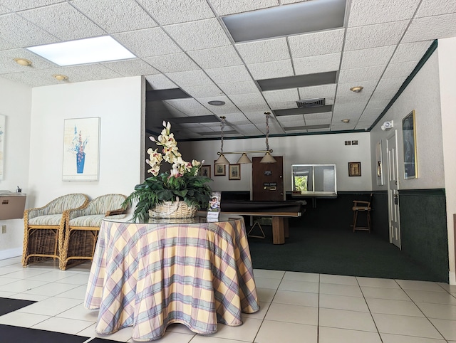 carpeted dining room featuring a drop ceiling