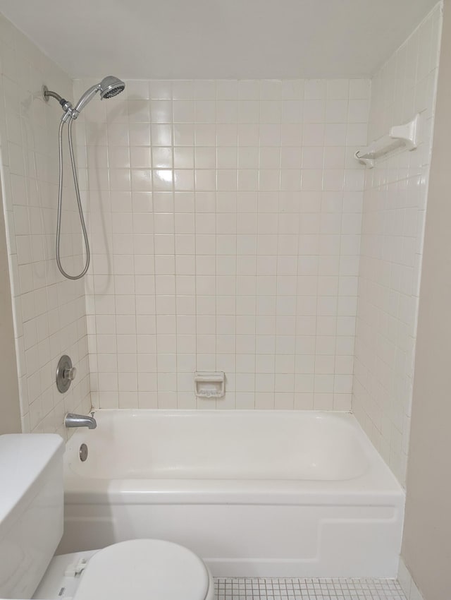 bathroom featuring tiled shower / bath combo and toilet