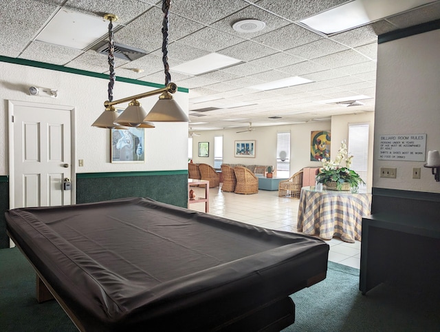 recreation room with a paneled ceiling, tile patterned floors, and billiards