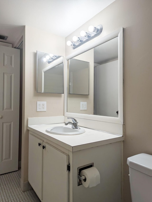 bathroom featuring tile patterned flooring, vanity, and toilet