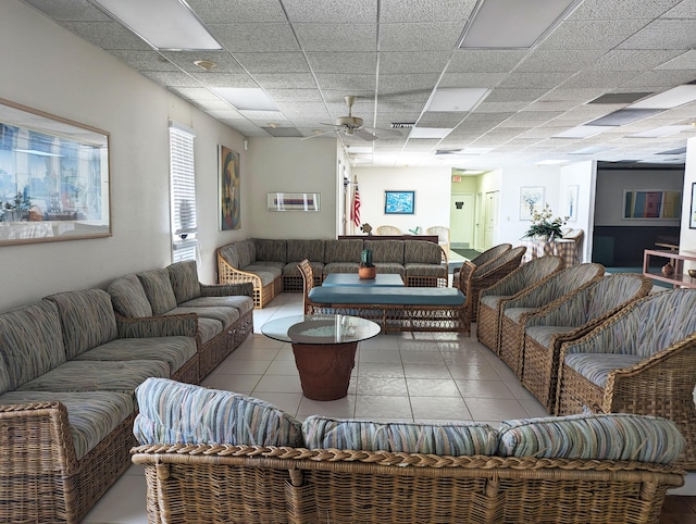 tiled living room featuring ceiling fan and a drop ceiling