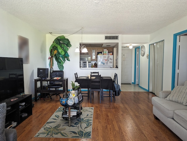 living room with a textured ceiling and wood-type flooring