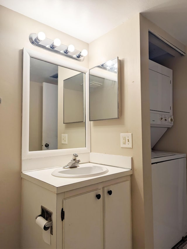 bathroom featuring vanity and stacked washer / dryer