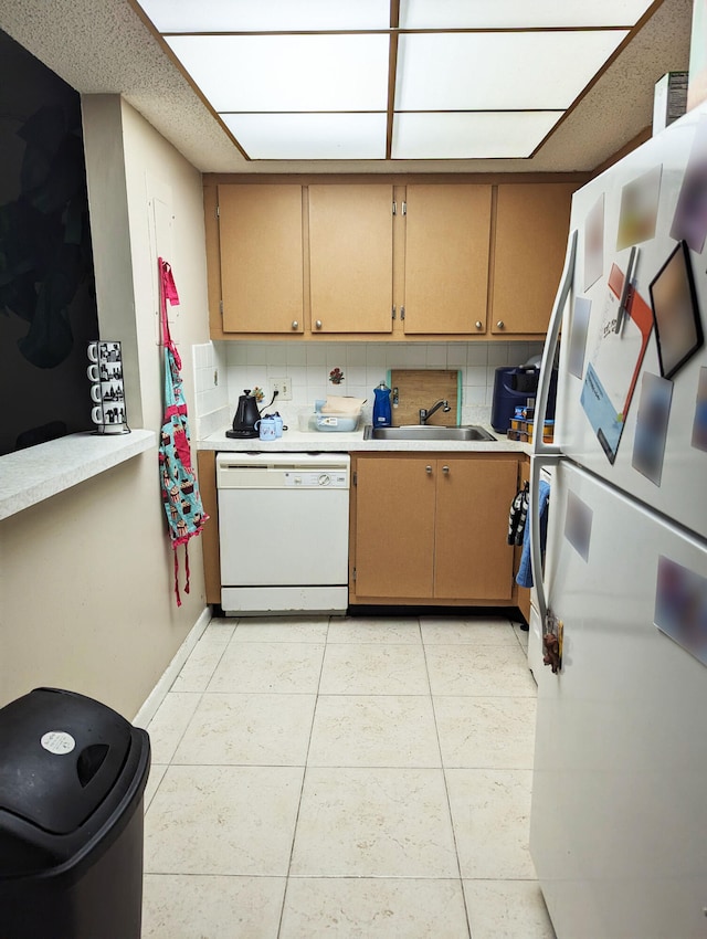 kitchen with sink, white appliances, light tile patterned floors, and decorative backsplash