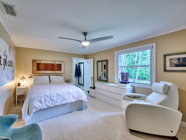 bedroom featuring ceiling fan, light hardwood / wood-style floors, and ornamental molding