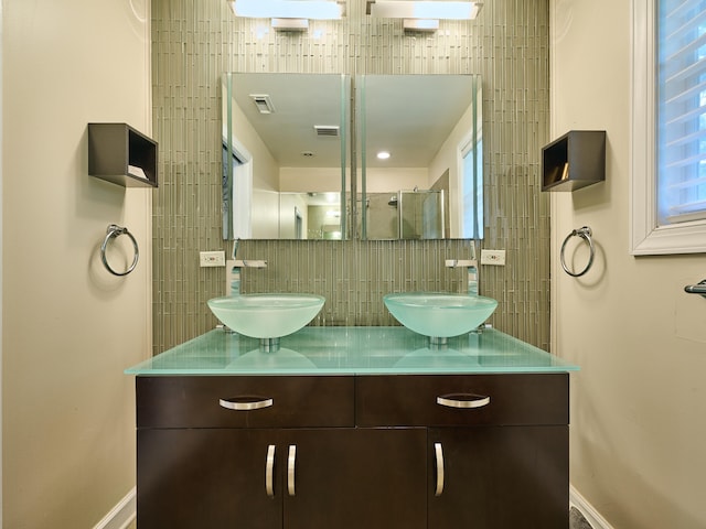 bathroom with vanity, backsplash, and walk in shower