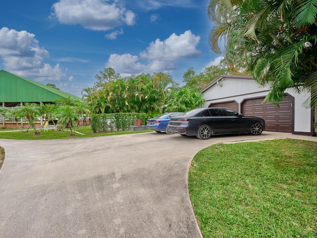 18238 128th Trl N, Jupiter, FL 33478 - view of side of property featuring concrete driveway, an attached garage, and a yard
