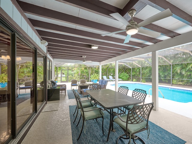 view of swimming pool with a patio area, ceiling fan, and glass enclosure