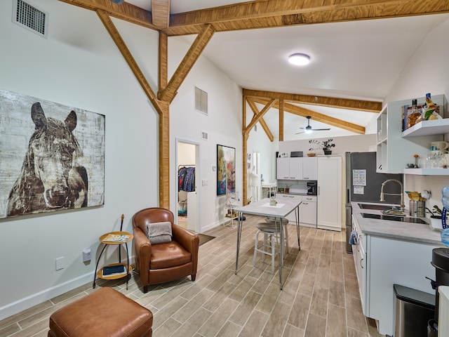 kitchen with white cabinets, ceiling fan, high vaulted ceiling, and beamed ceiling