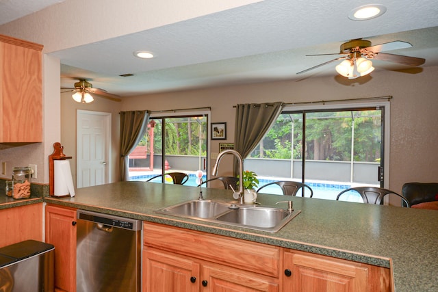 kitchen with stainless steel dishwasher, kitchen peninsula, sink, and ceiling fan