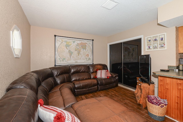 living room with dark wood-type flooring and a textured ceiling