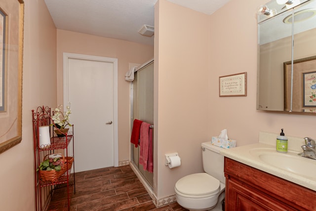 bathroom with toilet, walk in shower, and vanity