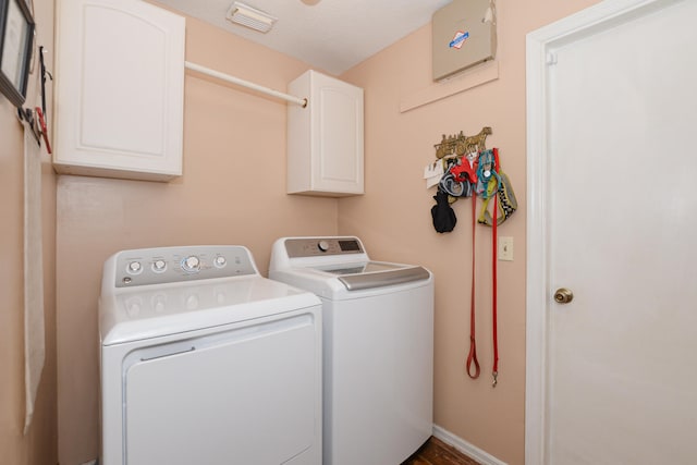 laundry area featuring washing machine and clothes dryer and cabinets