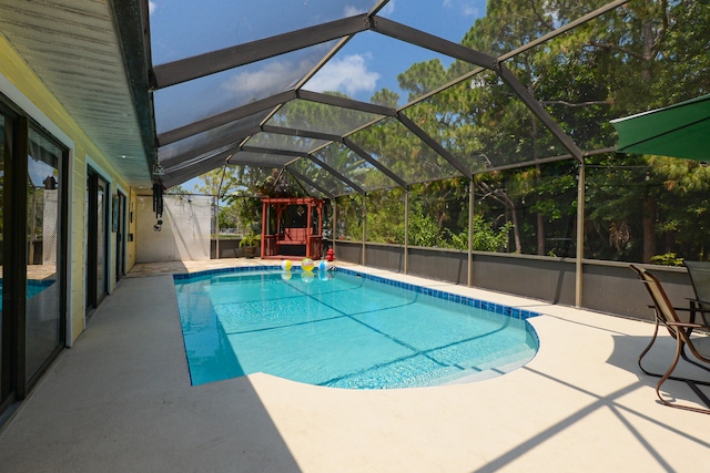 view of swimming pool with glass enclosure and a patio