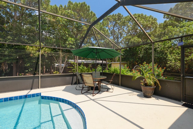 view of swimming pool with a patio and glass enclosure