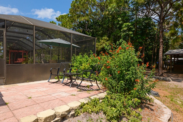 view of patio featuring glass enclosure