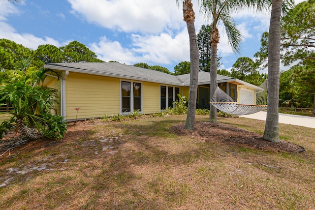 single story home featuring a front yard and a garage