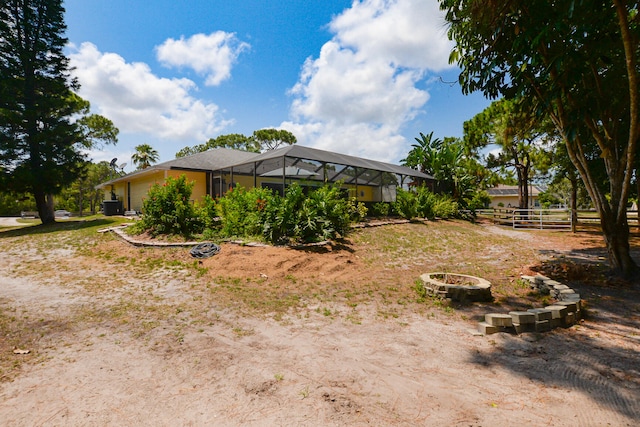 view of yard with glass enclosure and an outdoor fire pit