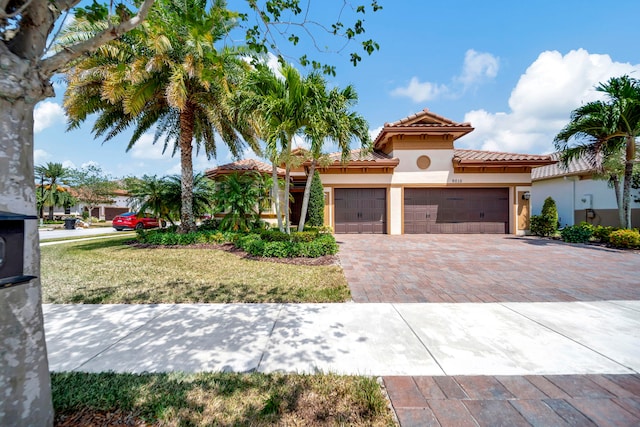 mediterranean / spanish-style house with a garage and a front yard