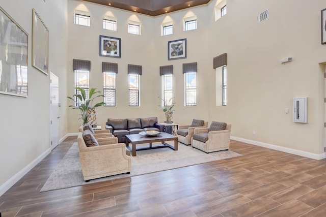 living room with a towering ceiling and hardwood / wood-style floors