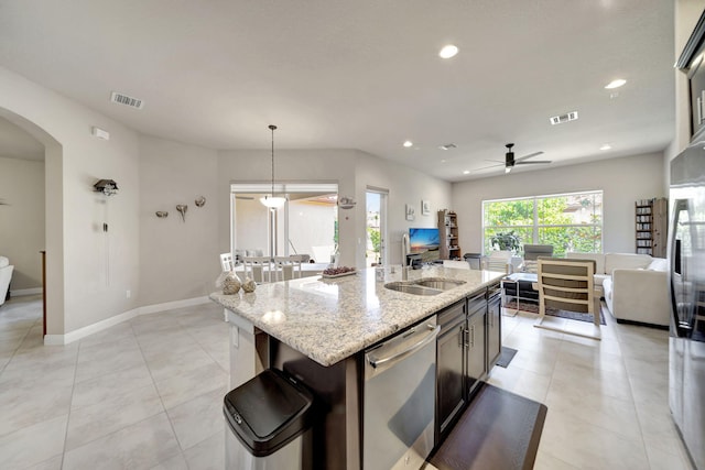 kitchen with stainless steel appliances, light stone counters, hanging light fixtures, an island with sink, and ceiling fan