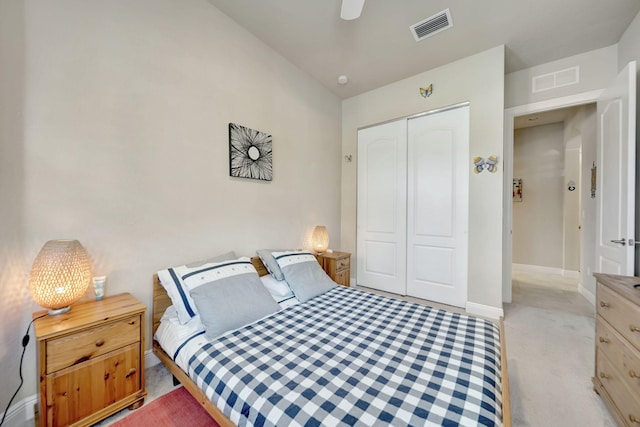 bedroom featuring light colored carpet, ceiling fan, and a closet