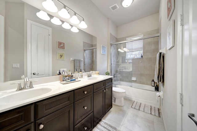 full bathroom featuring shower / bath combination with glass door, vanity, tile patterned floors, and toilet