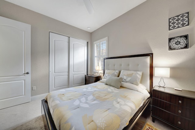 carpeted bedroom with lofted ceiling, ceiling fan, and a closet