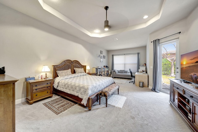 carpeted bedroom featuring a raised ceiling and access to exterior