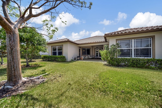 back of house featuring a lawn and a patio area