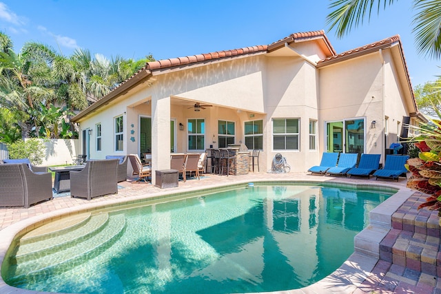 view of pool with a patio area, an outdoor living space, ceiling fan, and exterior bar